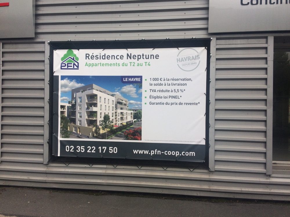 Bâche publicitaire à œillets tendue sur une façade au Havre